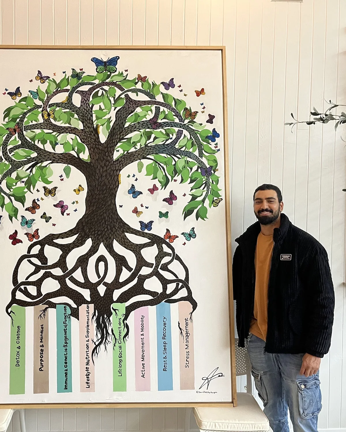 Amit Tejpal beside his large tree-of-life commission installed at HealHouse wellness centre in King City