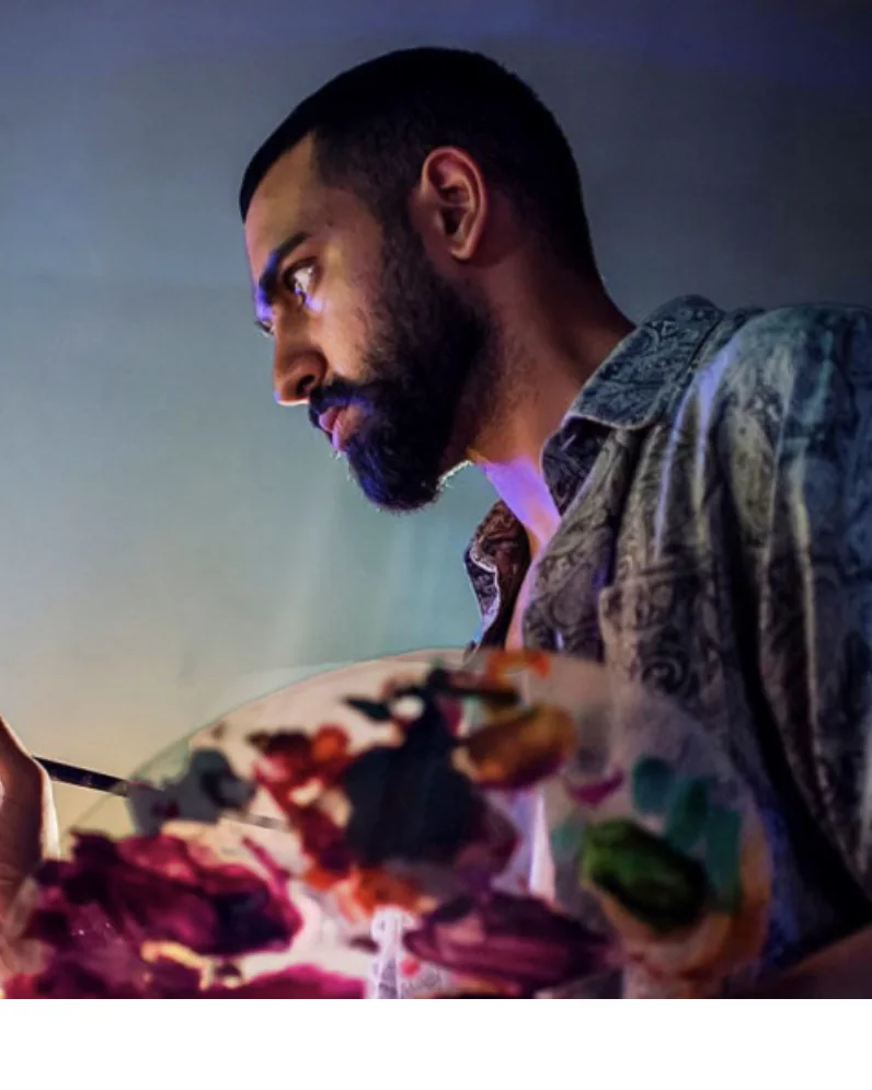Amit Tejpal painting with a palette in hand in the studio